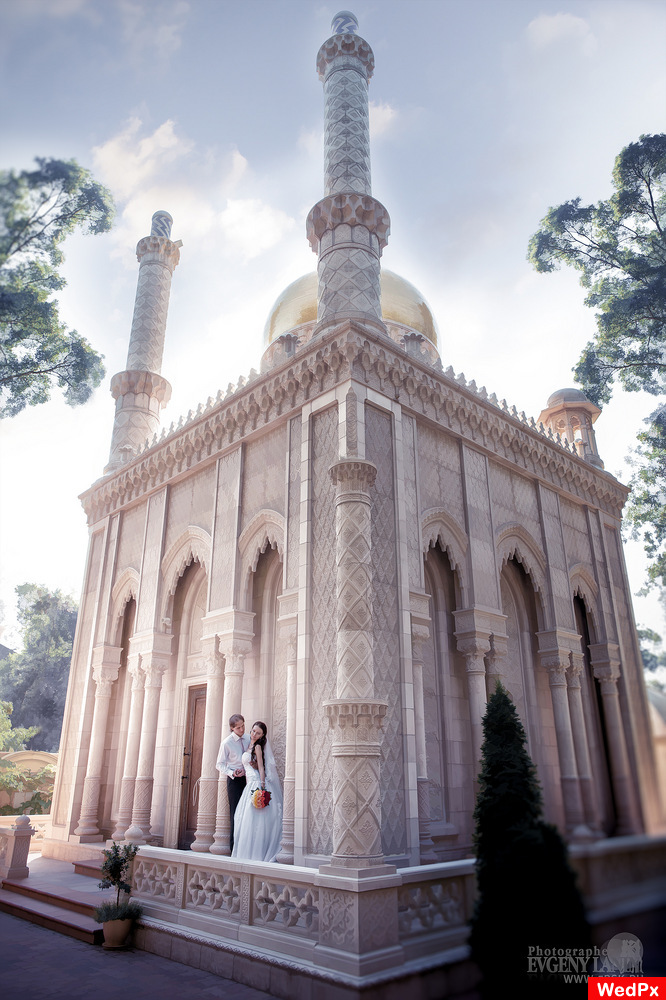 Bride and groom alongside a temple